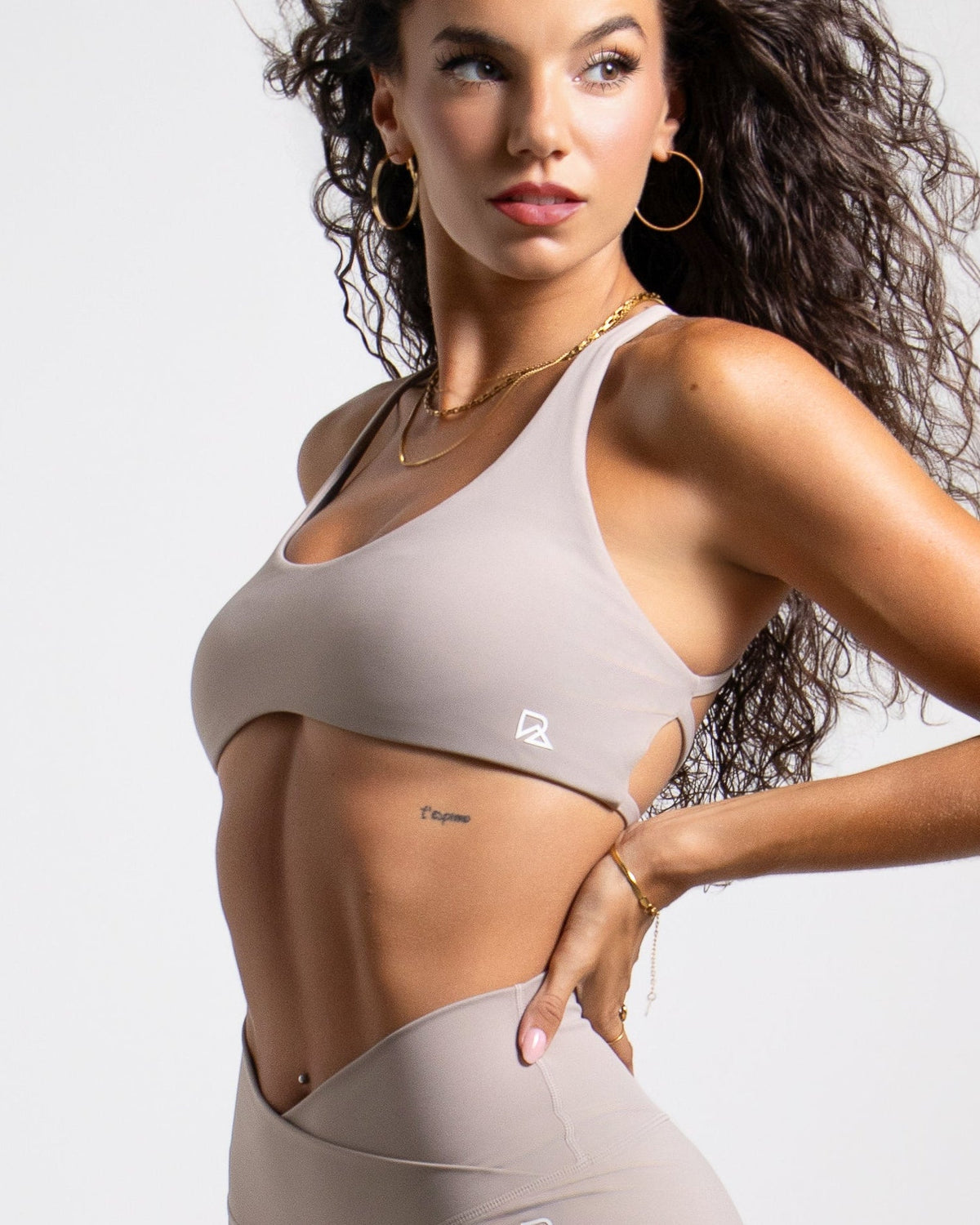 Strappy open-back sports bra in taupe — front view